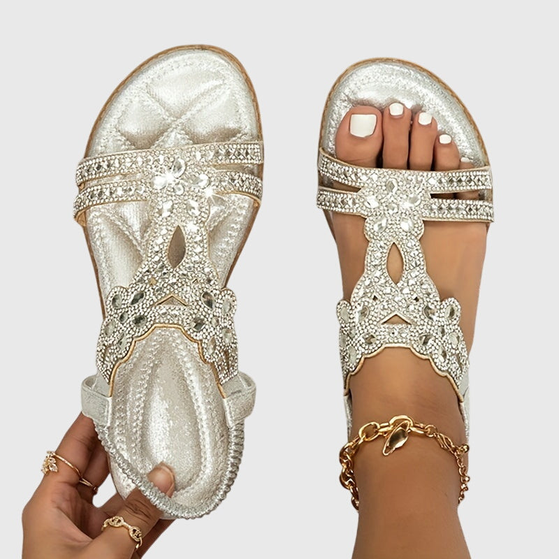 A woman wearing elegant gold open-front sandals with supportive straps and a cushioned sole.