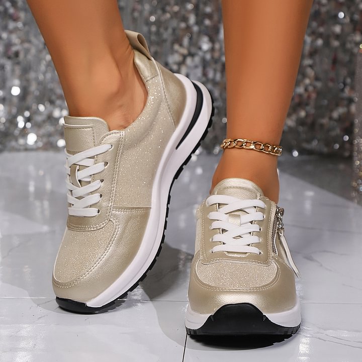 A woman in silver orthopaedic trainers with a handy side zip.