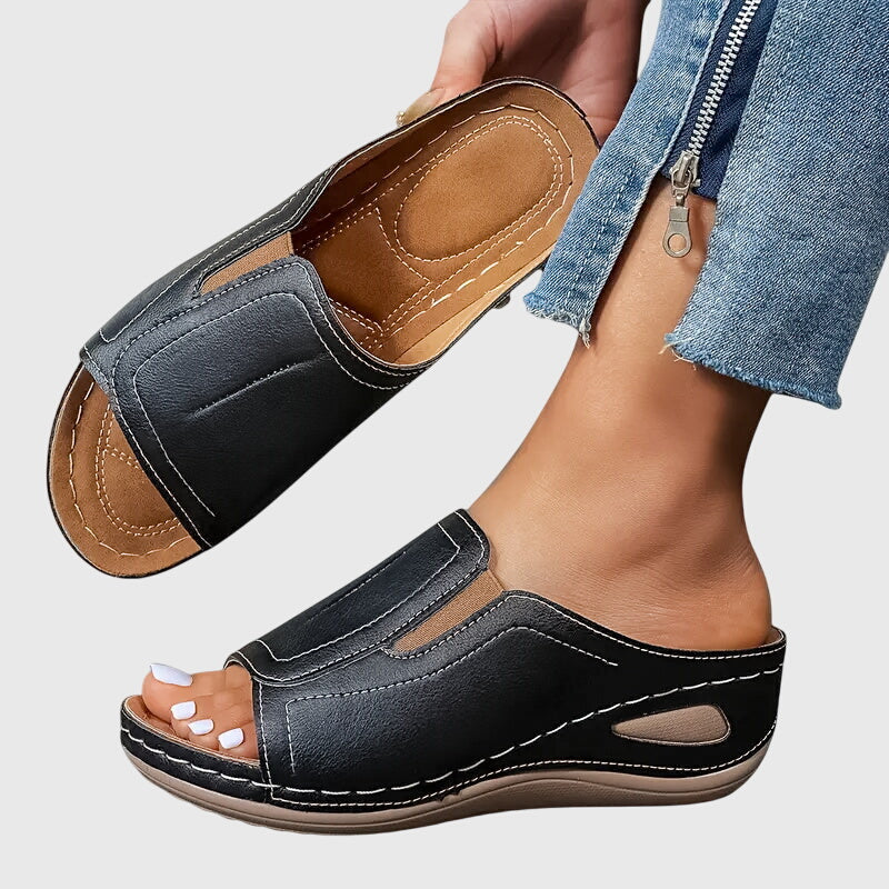 Tan open-toe wedge slides with a smooth one-piece upper and a cushioned wedge sole.