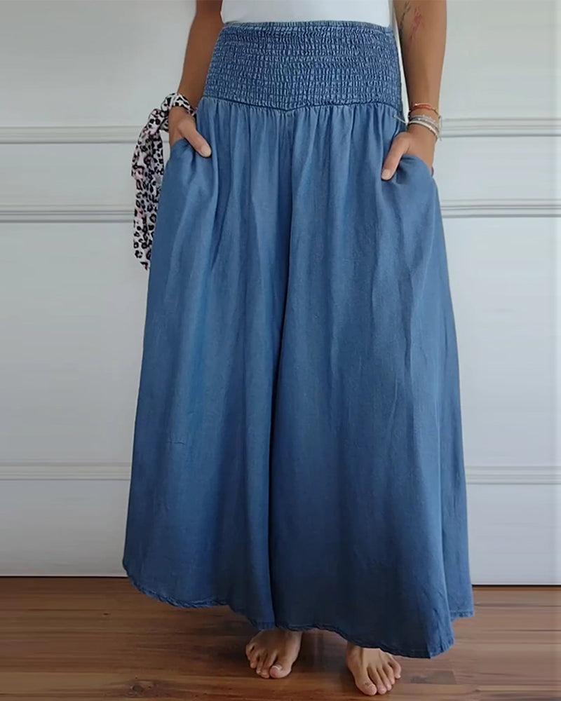 Woman wearing high-waist wide-leg trousers with a tucked-in blouse, mid-stride.