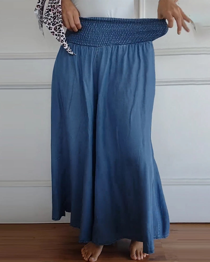Woman wearing high-waist wide-leg trousers with a tucked-in blouse, mid-stride.