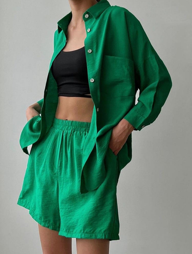 A woman wearing an oversized button-up shirt with matching high-waisted shorts.
