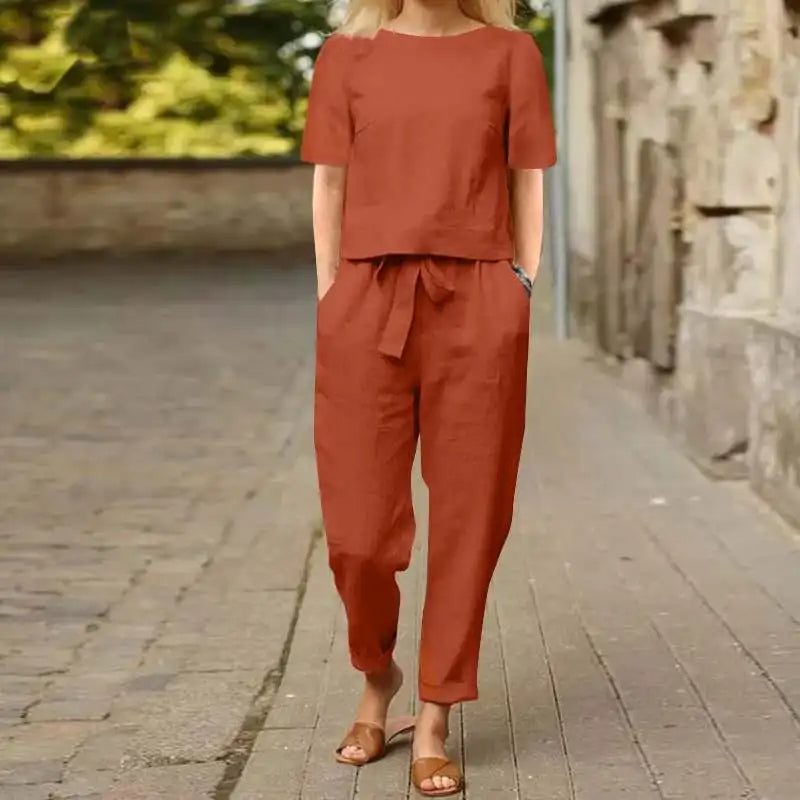 A woman wearing a relaxed short-sleeve top and matching drawstring trousers lounge set.