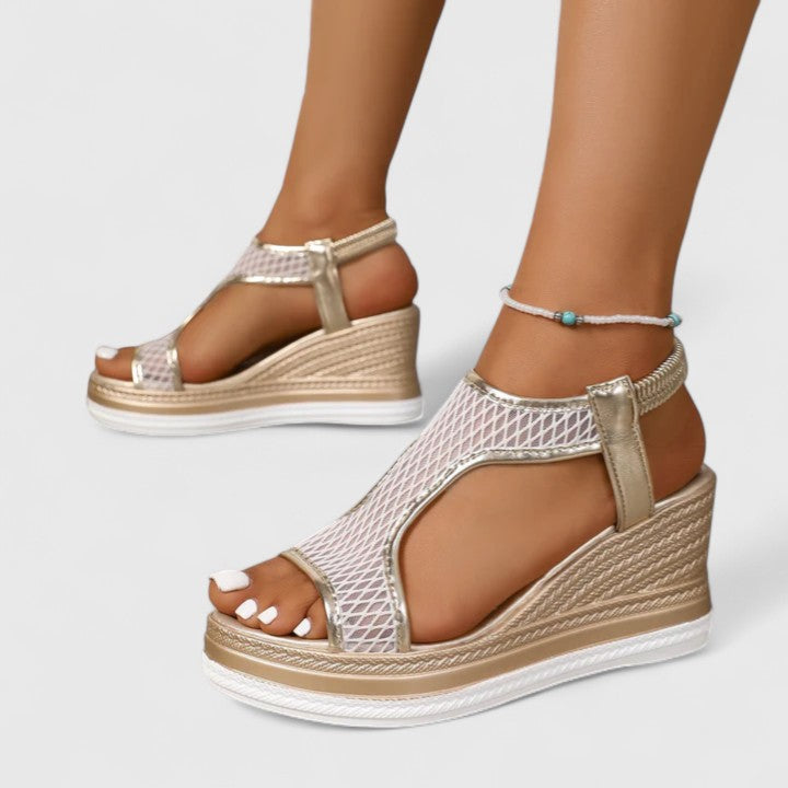 A woman wearing beige chic sandals with a cushioned sole and adjustable strap.