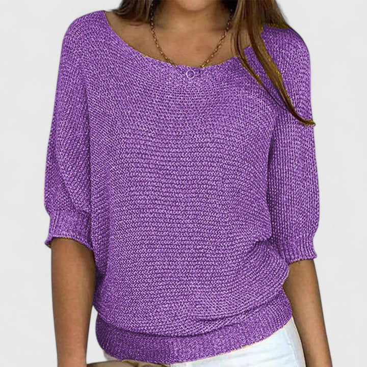 A woman wearing a soft purple jumper with a wide neckline and gently shaped fit.