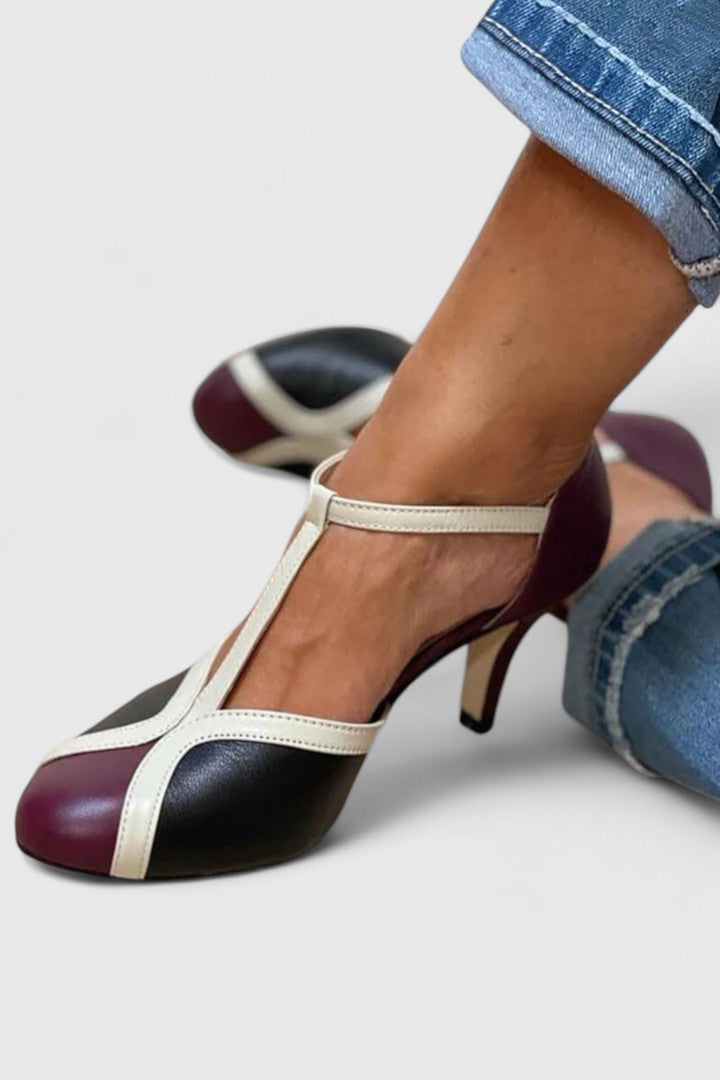 A woman wearing caramel T-strap heels, walking with grace and confidence.