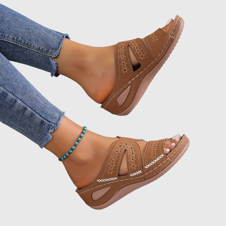 A woman walking gracefully in elegant wide-fit support sandals with an open-front design.