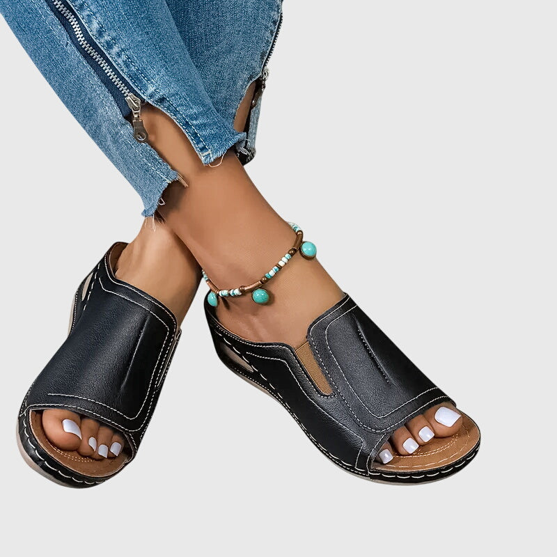 Tan open-toe wedge slides with a smooth one-piece upper and a cushioned wedge sole.