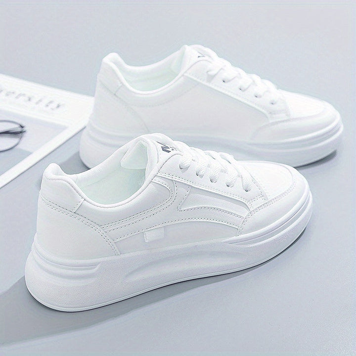 A woman in crisp white light comfort trainers paired with jeans.