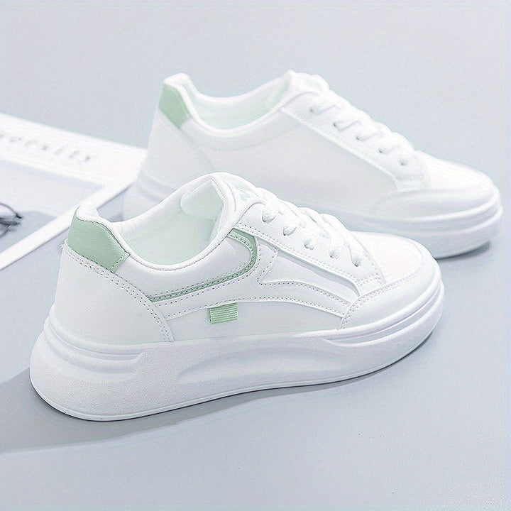 A woman in crisp white light comfort trainers paired with jeans.