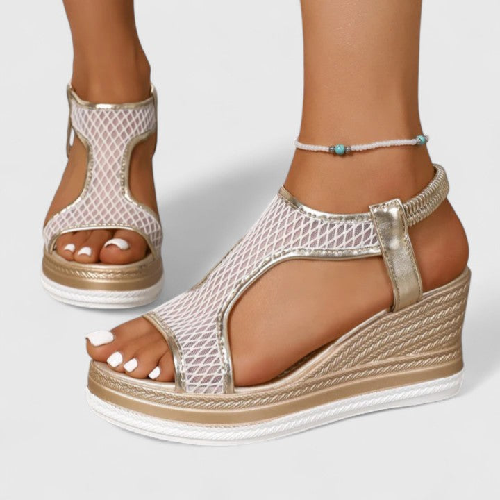 A woman wearing beige chic sandals with a cushioned sole and adjustable strap.