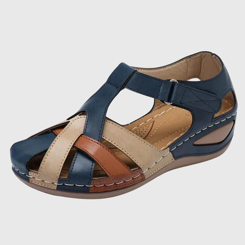 A woman in burgundy comfort sandals walking with ease on a sunny day, feet relaxed and supported.