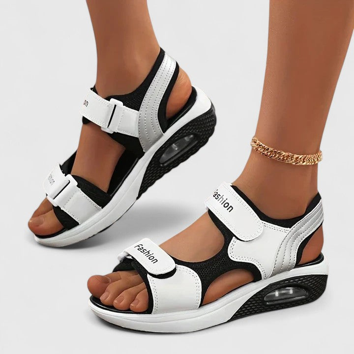 A woman in white sandals with a lilac trim walking comfortably, feet supported and light.