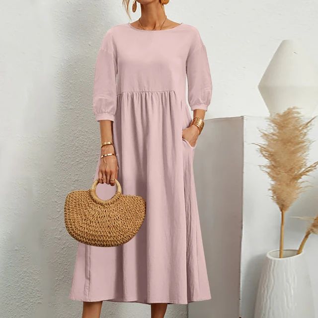 A woman wearing the Sheila fitted waist midi dress with three-quarter sleeves and a flowing skirt.