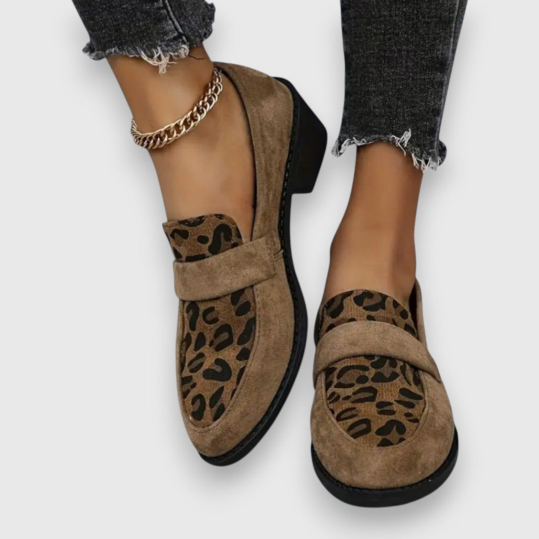 A woman wearing soft grey house slippers, relaxing comfortably at home.