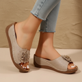 Beige wedge sandals with a delicate floral detail on the strap