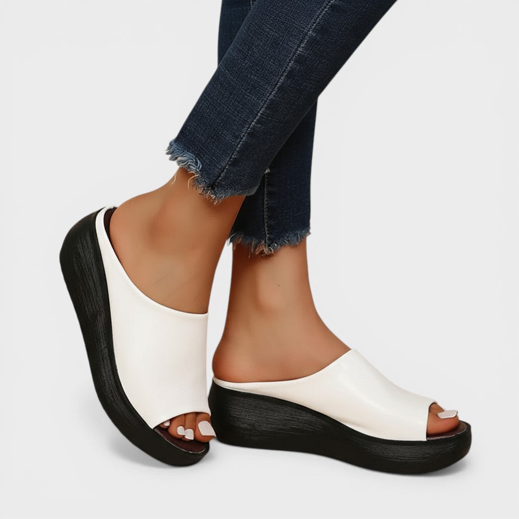 Open wedge mule sandals in white and brown with wide straps and a balanced wedge sole