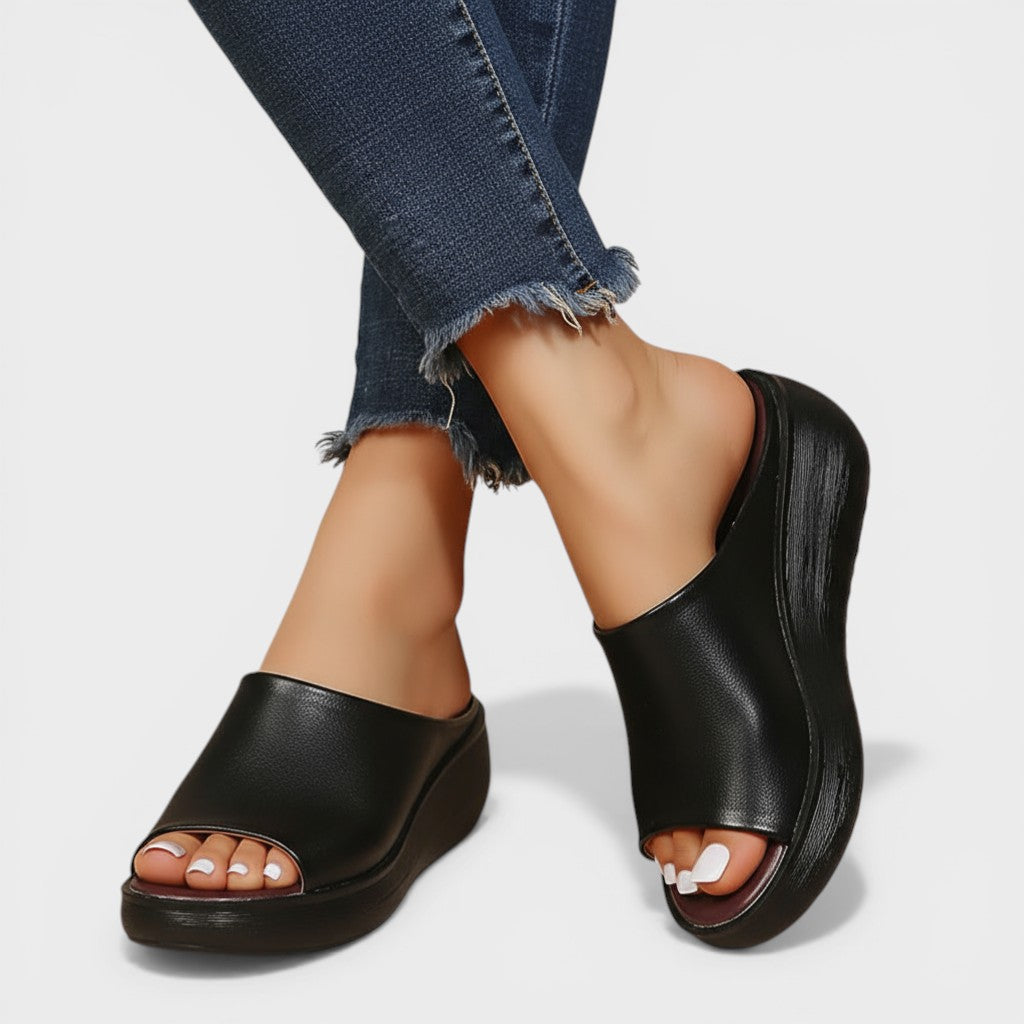 Open wedge mule sandals in white and brown with wide straps and a balanced wedge sole