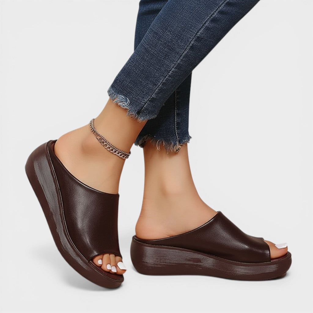 Open wedge mule sandals in white and brown with wide straps and a balanced wedge sole