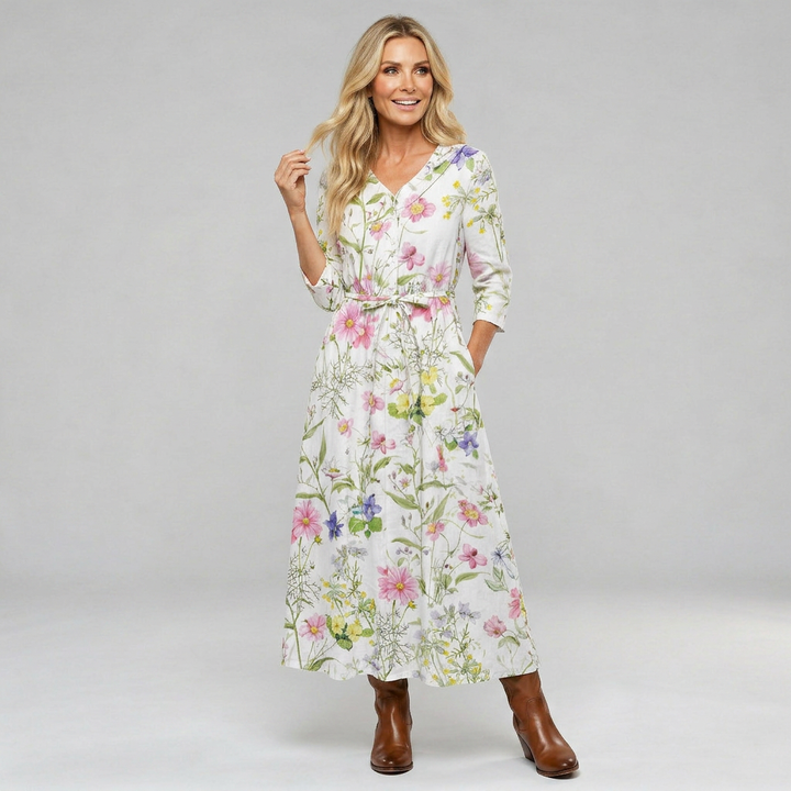 A woman wearing a floaty floral midi dress with an adjustable waist tie in a romantic print