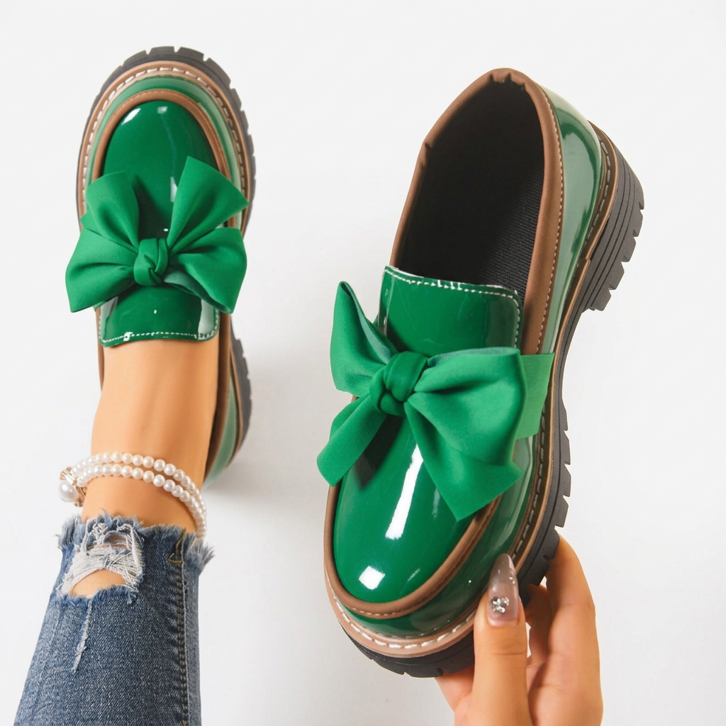 Green and black glossy loafers with a bold bow detail at the front