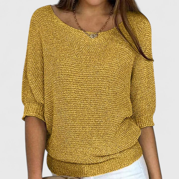 A woman wearing a soft purple jumper with a wide neckline and gently shaped fit.