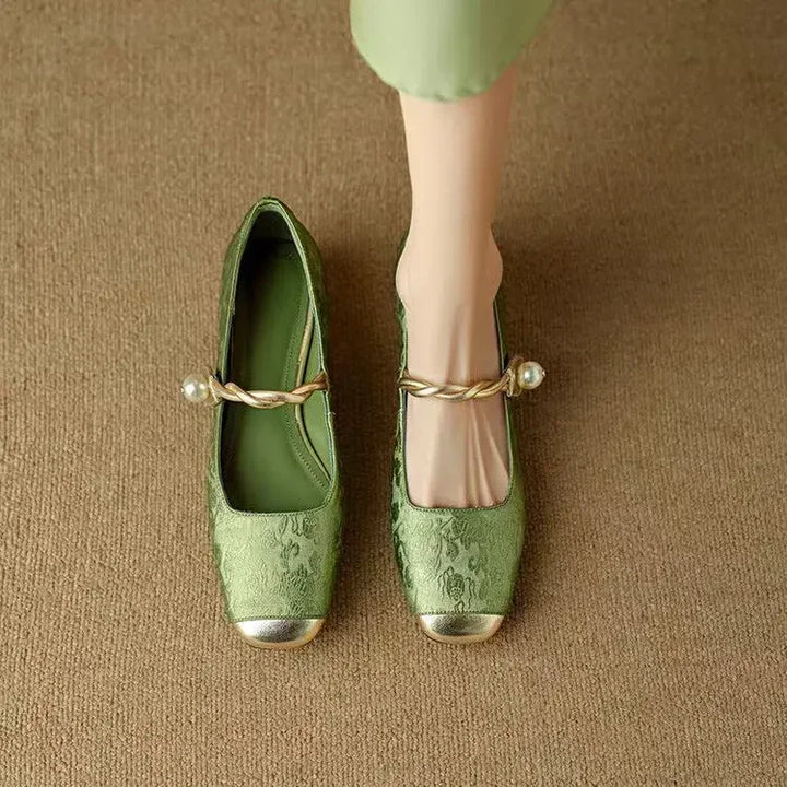 A woman wearing low-heel Mary Janes with a pearl-accented strap and a soft dress