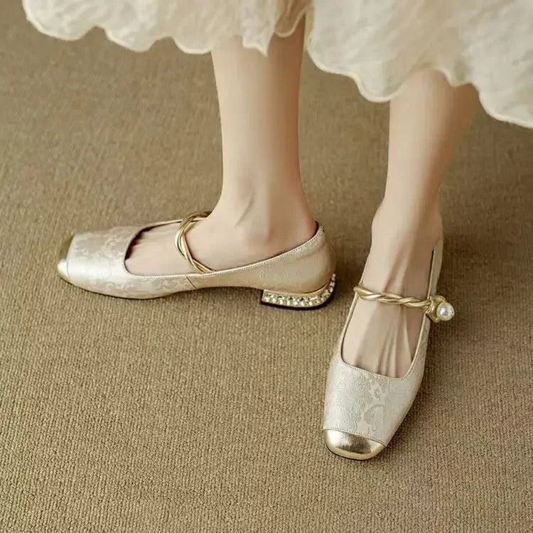 A woman wearing low-heel Mary Janes with a pearl-accented strap and a soft dress