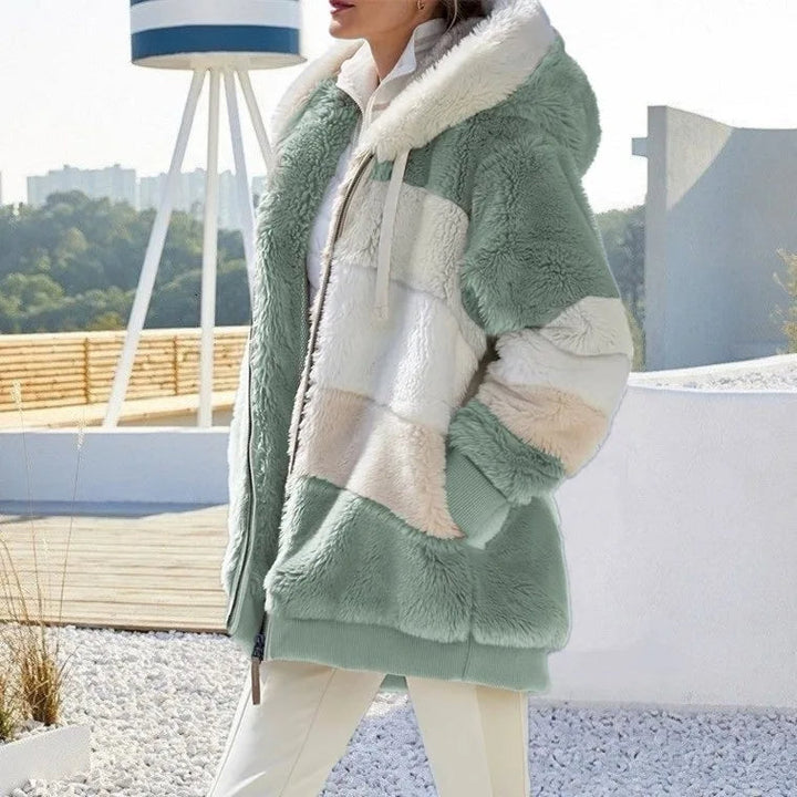 A woman wearing a hooded jacket with side pockets on a cold, rainy day out.
