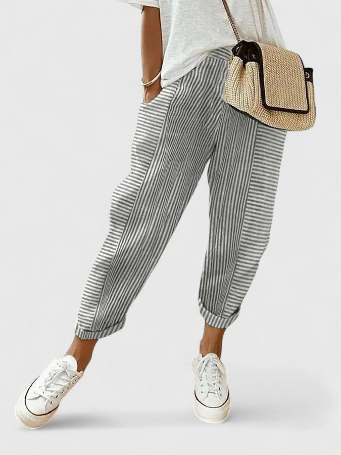A woman wearing airy comfy summer trousers with an elastic waist and side pockets.