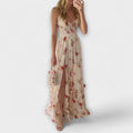 A white floral sleeveless fluid dress with a gentle print, styled for a casual summer occasion