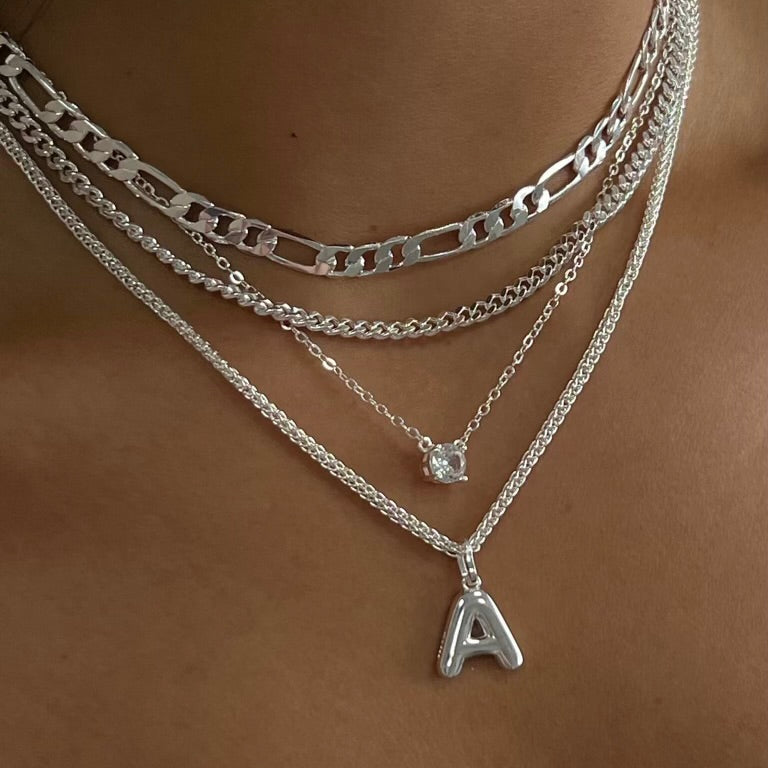 Layering necklace in gold and silver tones displayed on a clean background
