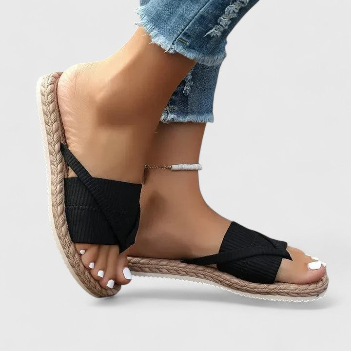 A woman moving freely in wide-fit open-front support sandals with a cushioned footbed.