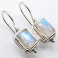 A pair of drop earrings featuring square-cut moonstone stones with a soft luminous glow
