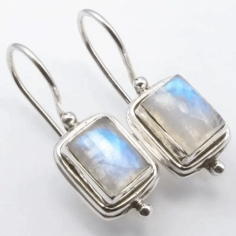 A pair of drop earrings featuring square-cut moonstone stones with a soft luminous glow