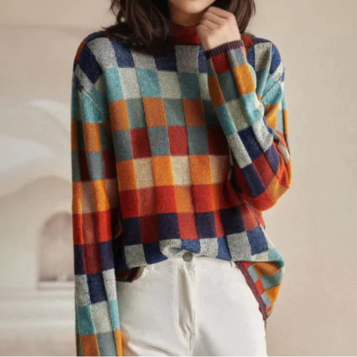 A woman wearing a colourful retro check jumper, relaxed and cosy on a cool autumn morning.