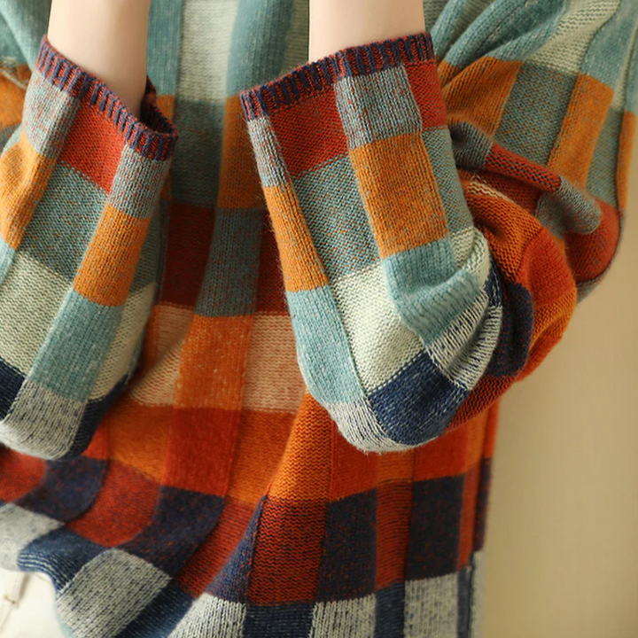 A woman wearing a colourful retro check jumper, relaxed and cosy on a cool autumn morning.