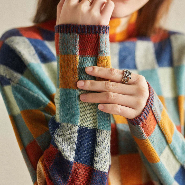 A woman wearing a colourful retro check jumper, relaxed and cosy on a cool autumn morning.