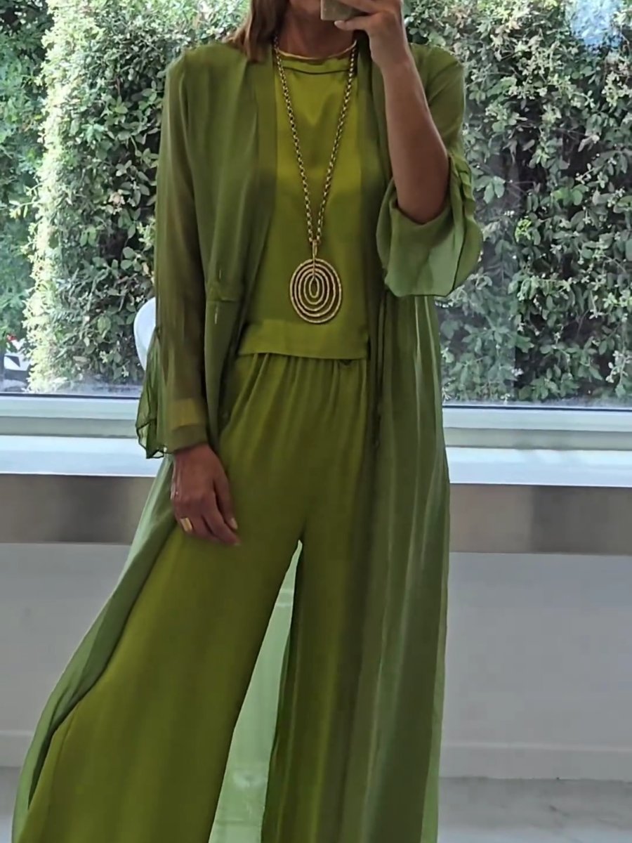 A woman wearing a flowing three-piece set with a sleeveless top, wide trousers and a long cardigan.