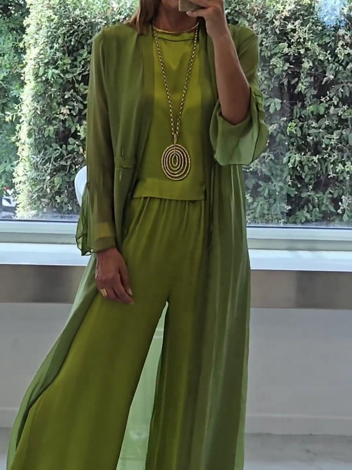 A woman wearing a flowing three-piece set with a sleeveless top, wide trousers and a long cardigan.
