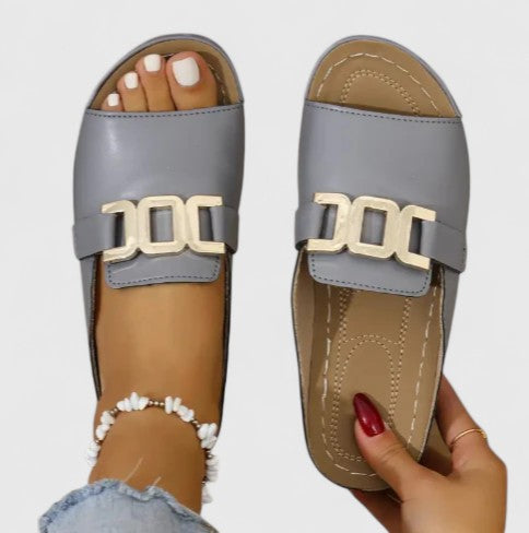 A woman walking easily in grey supportive sandals with a cushioned sole and adjustable strap.