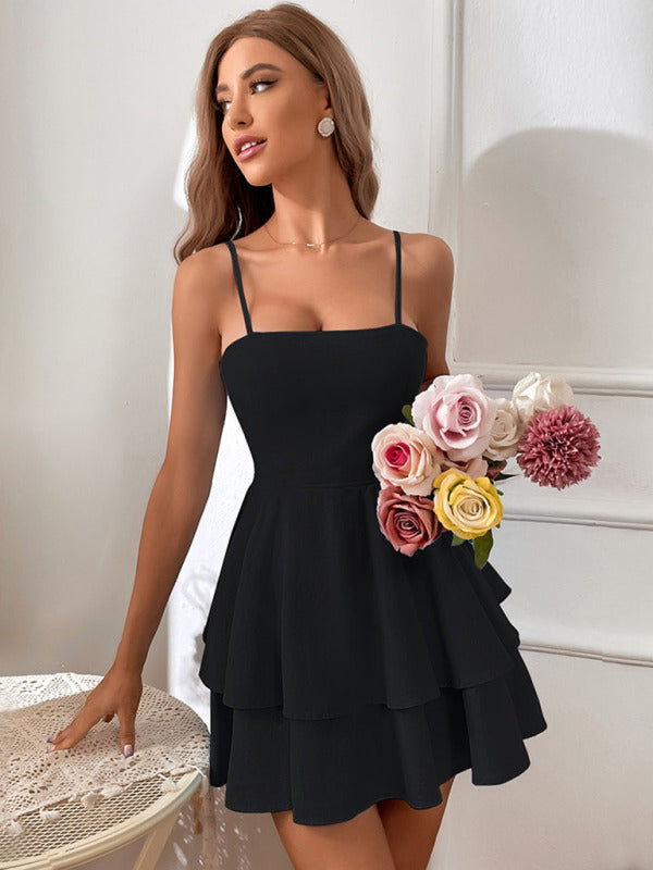 A white mini dress with open back, ruffle skirt and tie straps, styled for a summer evening occasion