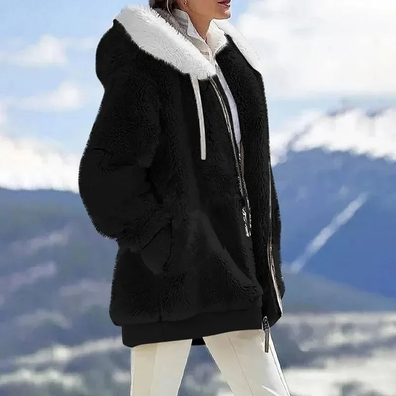 A woman wearing a hooded jacket with side pockets on a cold, rainy day out.