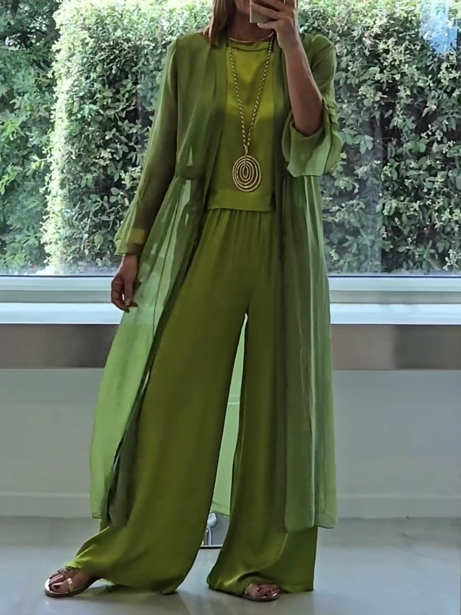 A woman wearing a flowing three-piece set with a sleeveless top, wide trousers and a long cardigan.