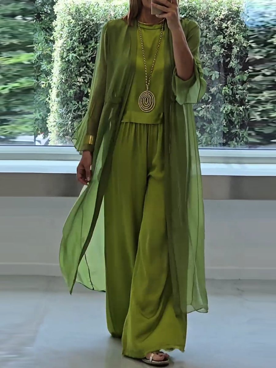 A woman wearing a flowing three-piece set with a sleeveless top, wide trousers and a long cardigan.