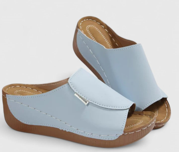 A woman in tan lightweight sandals stepping out gracefully, feet cushioned and supported.