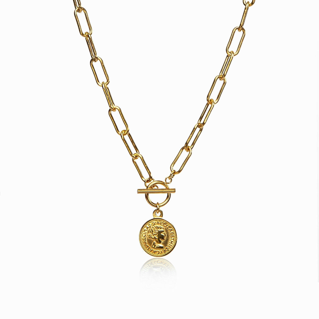 Delicate coin pendant necklace in gold tone on a white surface