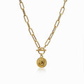 Delicate coin pendant necklace in gold tone on a white surface