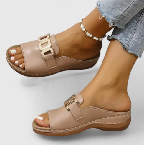 A woman walking easily in grey supportive sandals with a cushioned sole and adjustable strap.