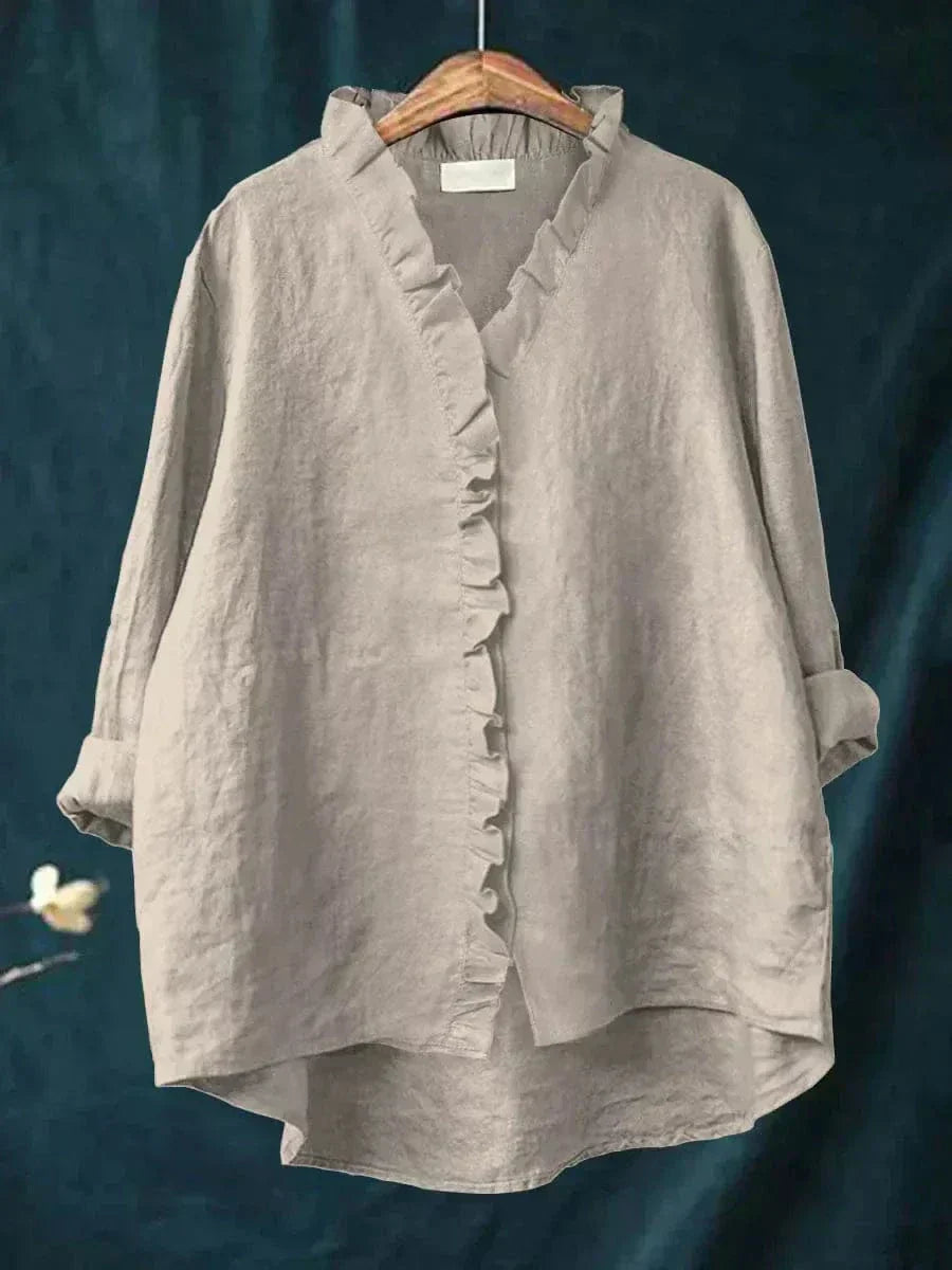 Woman wearing a plain ruffle-front summer blouse with a soft, flowing silhouette.